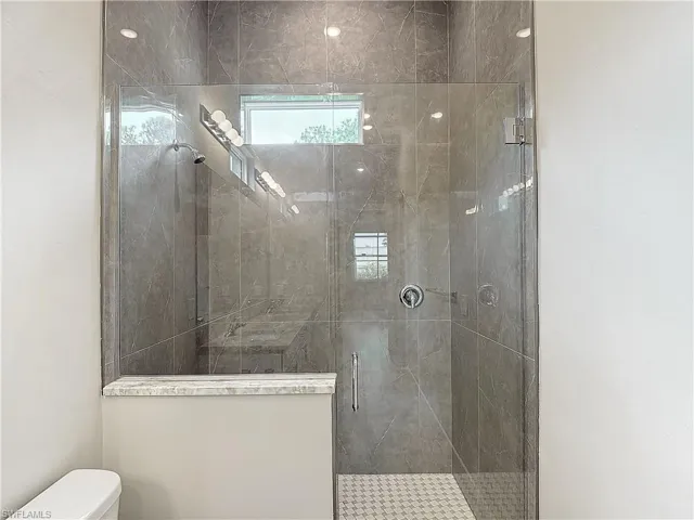 Bathroom with a shower with shower door and toilet