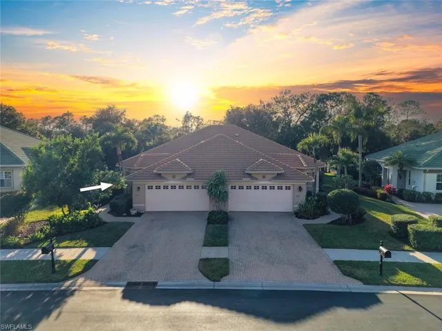 View of front of house featuring driveway, a garage, and a tile roof