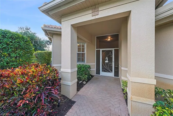 Entrance to property with stucco siding and screened door.