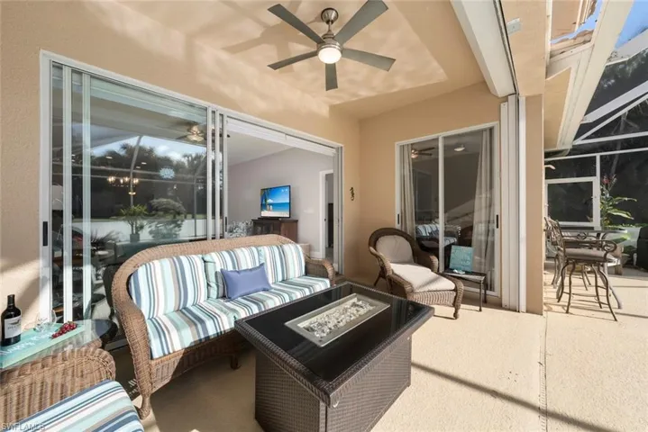 View of patio with an outdoor living space with a fire pit, ceiling fan, and a lanai