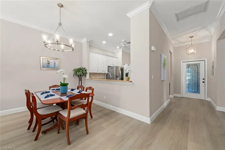 Dining area featuring a chandelier, light wood-type flooring, crown molding, recessed lighting, and a ceiling fan
