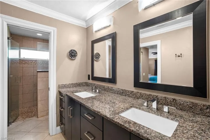 Primary bath offers his and her vanity areas, glassed open shower and substantial lighting.