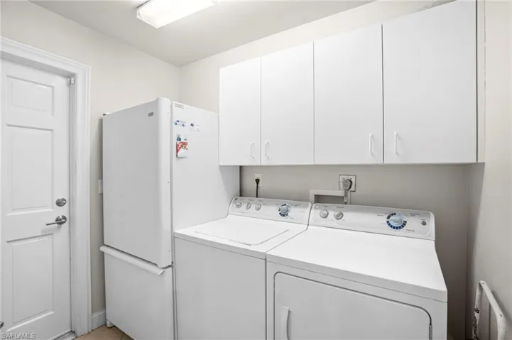Utility is just off kitchen and offers storage cabinets, refrigerator with ice maker, washer and dryer.