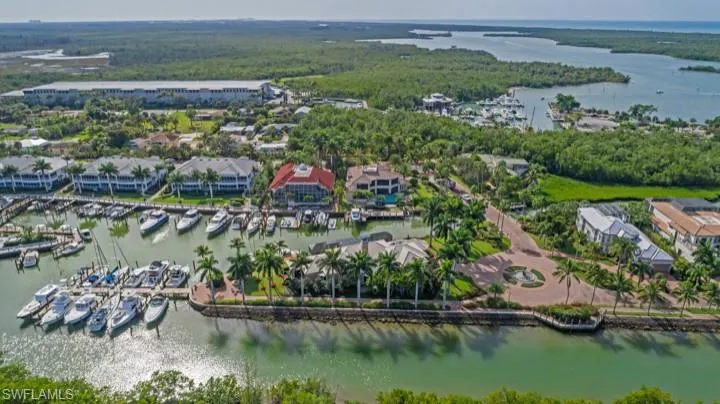 Aerial overview of property's location with a large body of water, numerous boat docks, and nearby suburban area