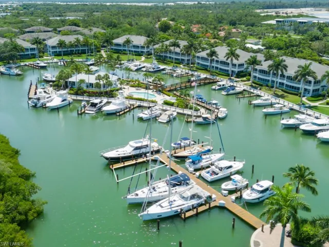Drone / aerial view of numerous boat docks and a nearby body of water