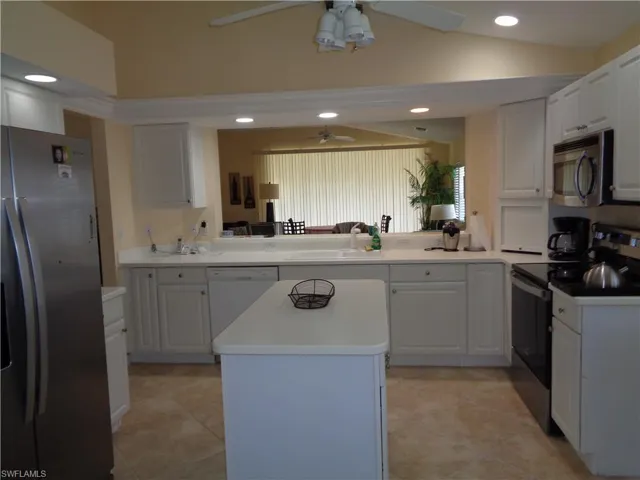Kitchen featuring stainless steel appliances, a kitchen island, recessed lighting, white cabinetry, and light tile patterned floors