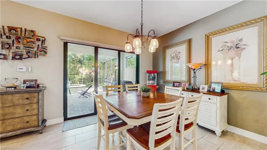 TABLE W 8 CHAIRS, ALL TILE, LIGHTING, HIGH CEILINGS, 3 PANEL DLIDING DOOR TO POOL AREAnotable chandelier, and baseboards