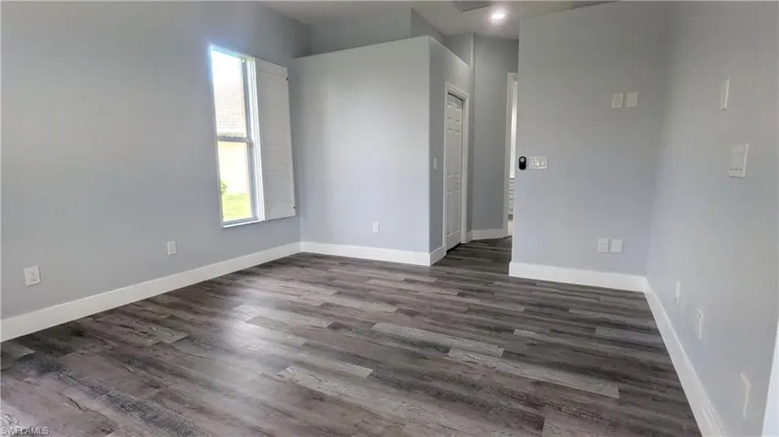 Empty room featuring dark hardwood / wood-style floors