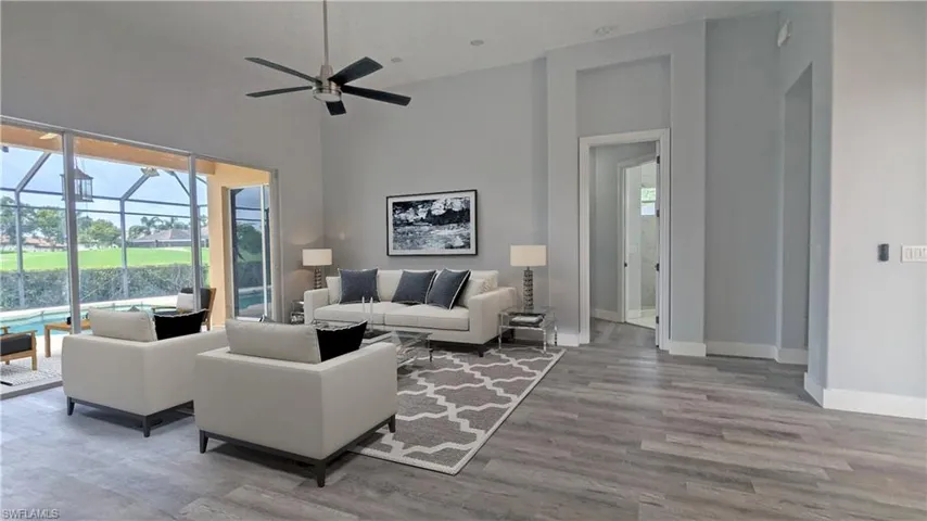 Living room featuring a healthy amount of sunlight, high vaulted ceiling, hardwood / wood-style flooring, and ceiling fan