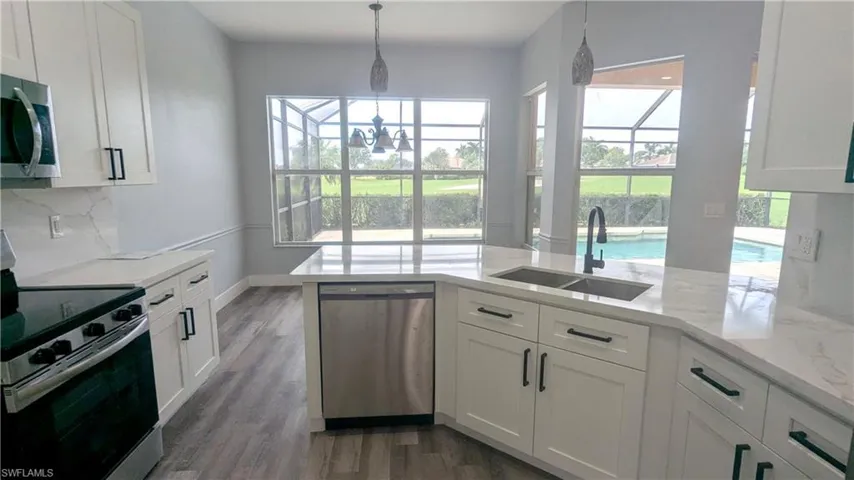 Kitchen featuring appliances with stainless steel finishes, white cabinetry, and plenty of natural light