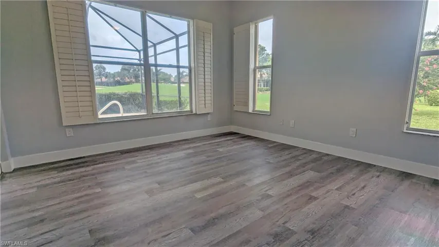 Unfurnished room with a healthy amount of sunlight and hardwood / wood-style flooring