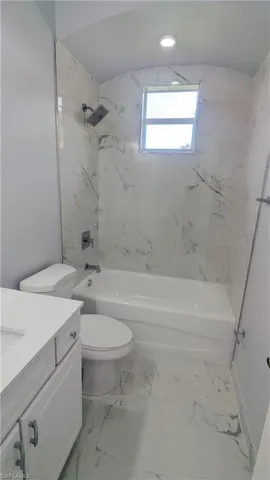 Full bathroom with vanity, toilet, and tiled shower / bath