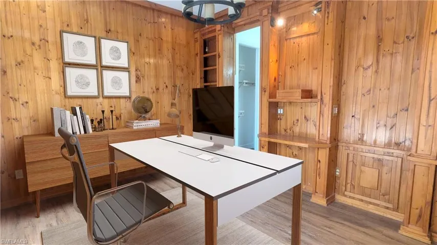 Office space with wooden walls and light hardwood / wood-style floors