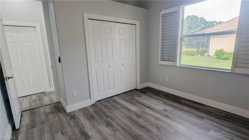 Unfurnished bedroom with dark hardwood / wood-style flooring