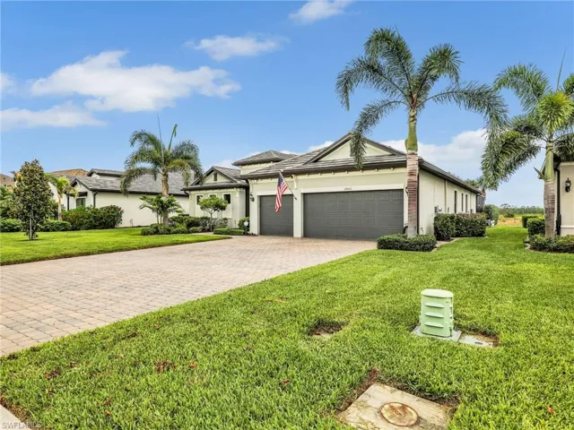 3 Car garage with paved driveway and flat tile roof