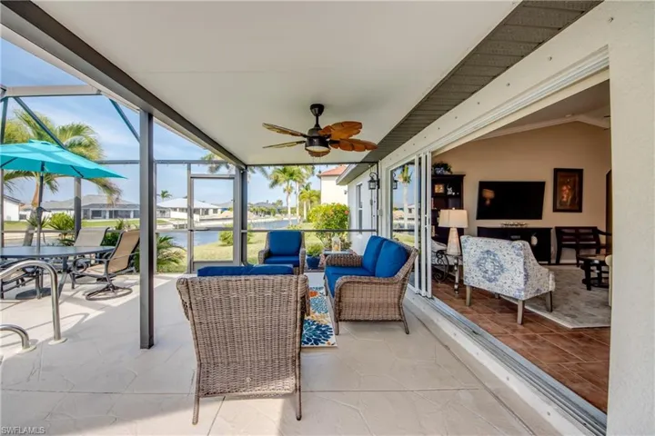 Sunroom featuring a patio, a residential view, a ceiling fan, and an outdoor living / dining area