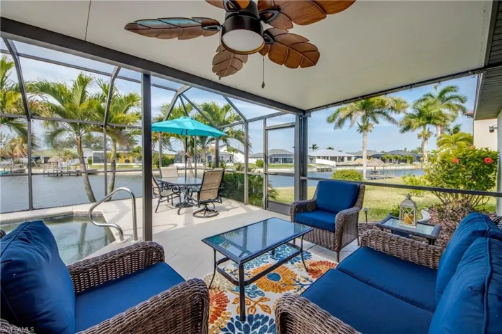 Sunroom / solarium with a water view, a residential view, healthy amount of natural light, and a ceiling fan
