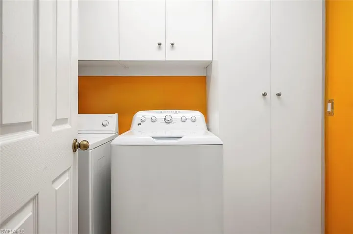 Washroom featuring cabinet space and washer and clothes dryer