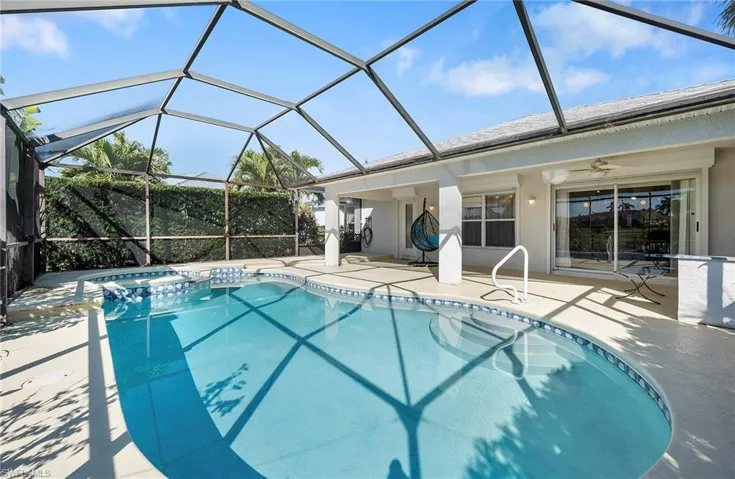 View of swimming pool with a sunroom, a patio area, glass enclosure, and a pool with connected hot tub