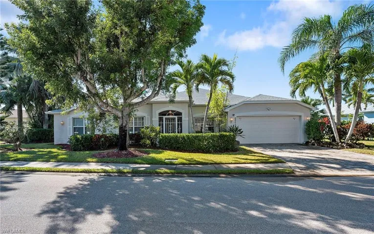 View of front of property featuring stucco siding, an attached garage, driveway, and a front lawn