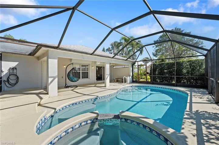 View of swimming pool featuring a sunroom, a pool with connected hot tub, a patio, and a lanai