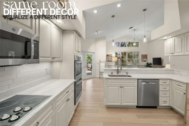 Kitchen with stainless steel appliances, hanging light fixtures, recessed lighting, white cabinets, and a peninsula