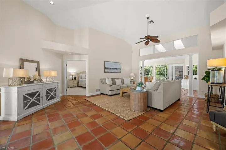 Tiled living area with high vaulted ceiling and a ceiling fan
