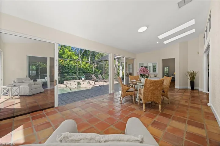 Sunroom / solarium featuring lofted ceiling, a patio area, outdoor dining area, and a skylight