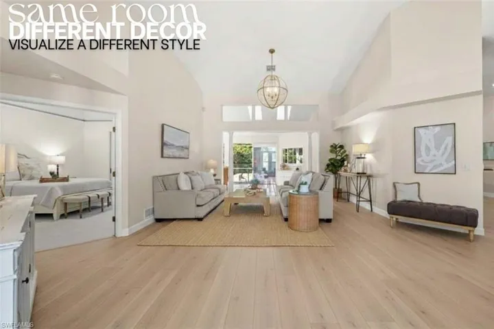 Living area featuring light wood-style flooring, a chandelier, and high vaulted ceiling