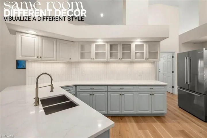 Kitchen with high end fridge, gray cabinetry, light wood-style floors, backsplash, and glass insert cabinets