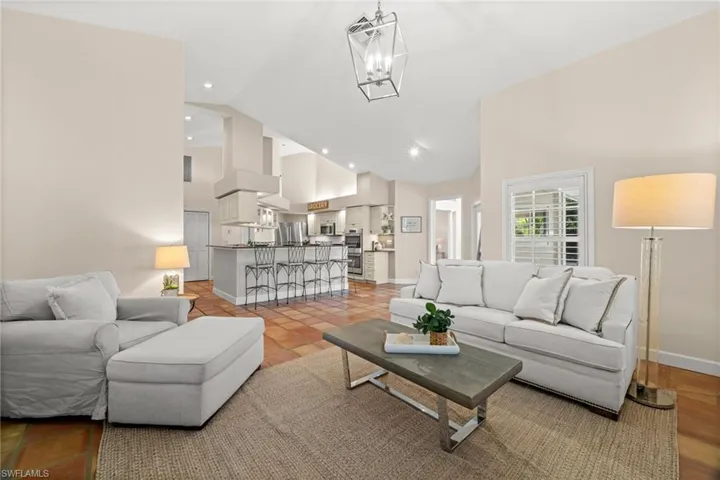 Living room featuring high vaulted ceiling, a chandelier, and recessed lighting