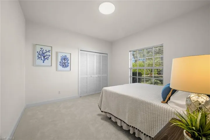 Carpeted bedroom featuring baseboards and a closet