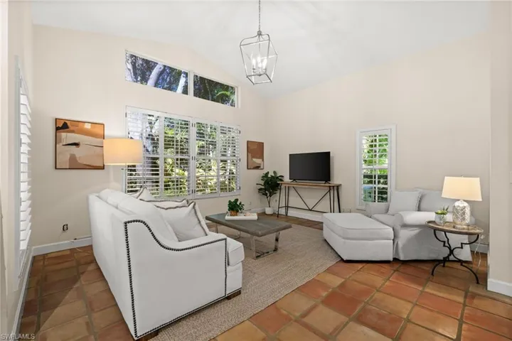 Living room featuring high vaulted ceiling and a chandelier