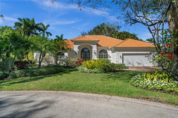 Mediterranean / spanish home featuring stucco siding, a tiled roof, a front lawn, and a garage