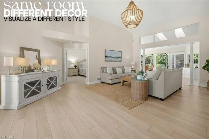 Living room with light wood-type flooring, high vaulted ceiling, and a chandelier