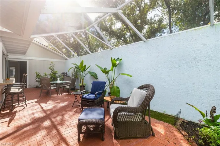 View of patio with a sunroom, a lanai, and outdoor dining area