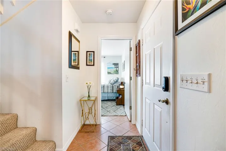 Corridor with stairs and light tile patterned floors