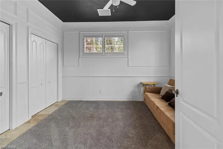 Sitting room featuring carpet flooring, ceiling fan, and crown molding