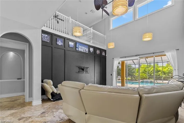 Living room with ornamental molding, a high ceiling, and ceiling fan