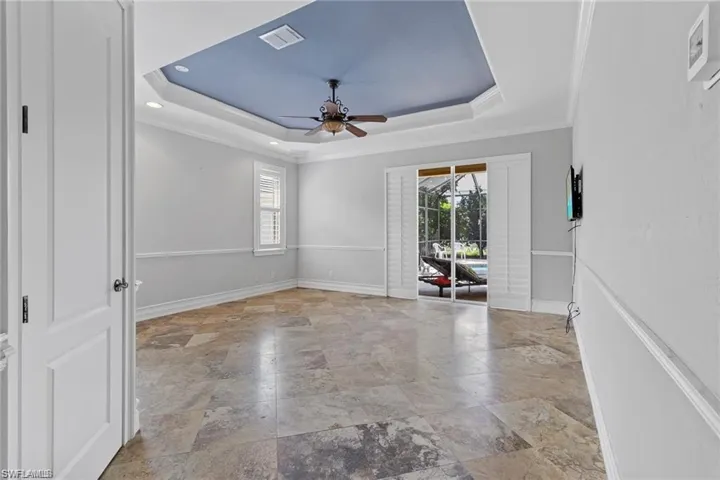 Unfurnished room with ceiling fan, a raised ceiling, and crown molding
