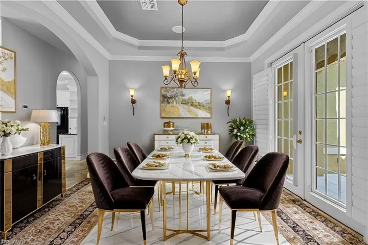 VIRTUAL STAGING  Dining room featuring a raised ceiling, crown molding, and a chandelier