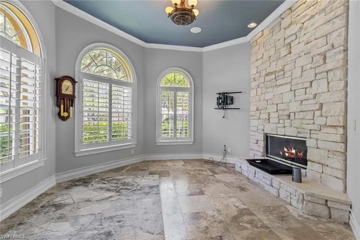 Unfurnished living room with a fireplace and crown molding