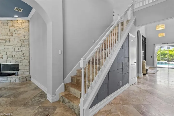 Staircase featuring crown molding and a fireplace