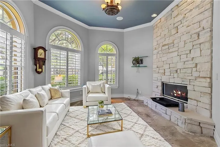 VIRTUAL STAGING Living room featuring a fireplace, crown molding, and a healthy amount of sunlight