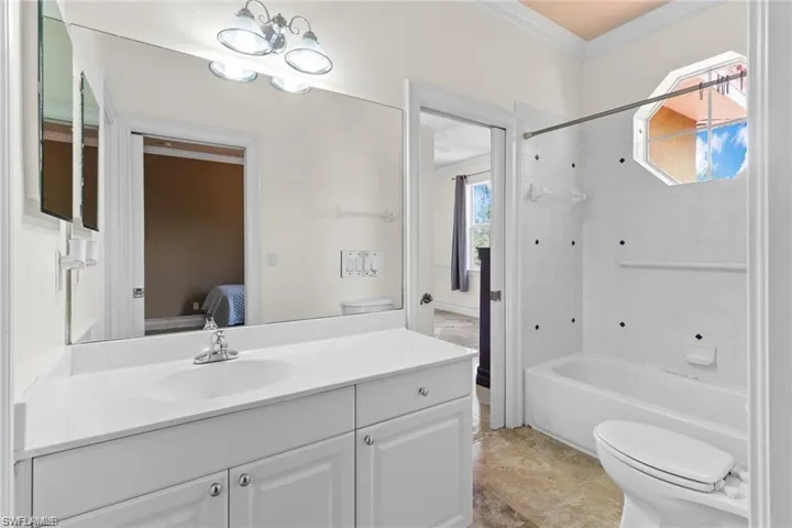Full bathroom featuring crown molding, vanity, toilet, and shower / washtub combination