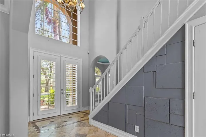 Entrance foyer featuring plenty of natural light, a towering ceiling, and french doors