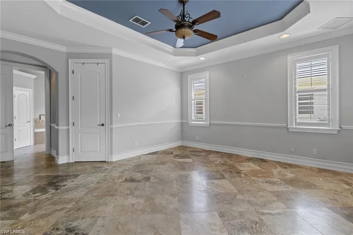 Unfurnished room featuring crown molding, a raised ceiling, and ceiling fan