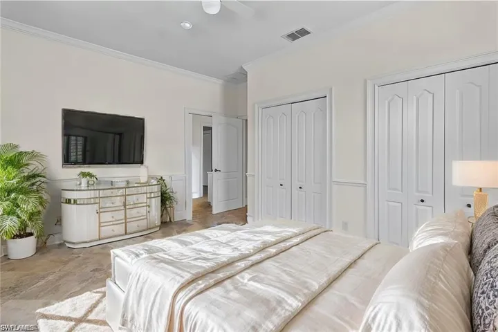 VIRTUAL STAGING  Bedroom featuring multiple closets, crown molding, and ceiling fan