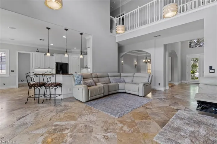 Living room featuring a high ceiling, a chandelier, and crown molding