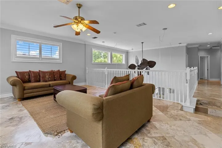 Living room featuring ceiling fan and crown molding